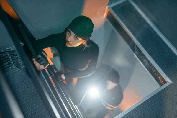 Bank robbery of the century, two robbers in black uniform make their way into the vault. Criminal profession, theft concept
