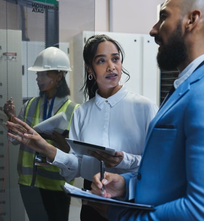 Shot of two workers inspecting the electronic equipment in a server room together at work.