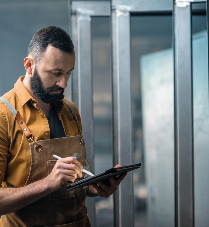 Engineer or factory worker using digital technology in the production of metal products, using a digital tablet at the plant. High quality photo